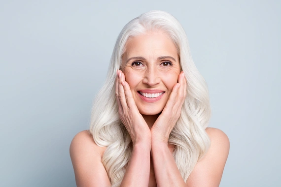 Woman smiling confidently after dental implant restoration.