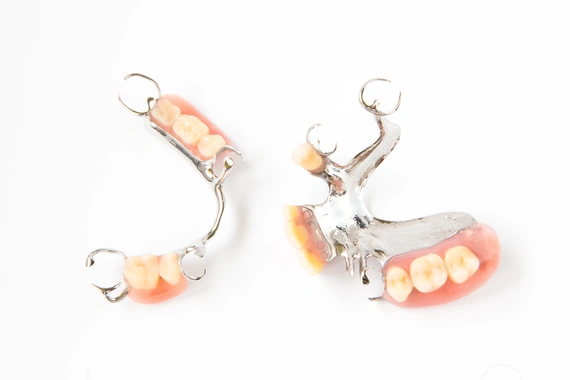Image of a partial denture showcasing a pink base and replacement teeth.