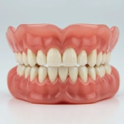 Close-up of custom-made dentures on a neutral background.