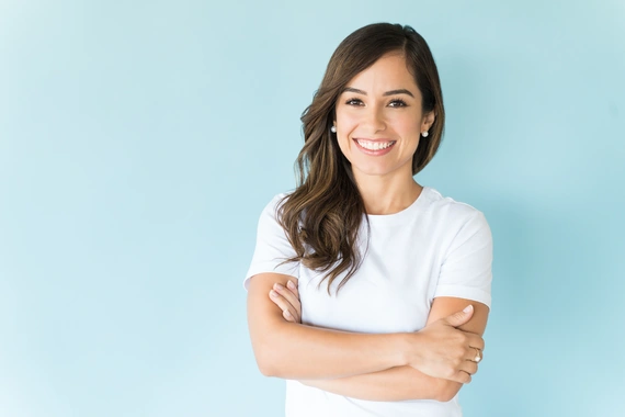 Smiling woman, highlighting the importance of dental care and fluoride treatments.